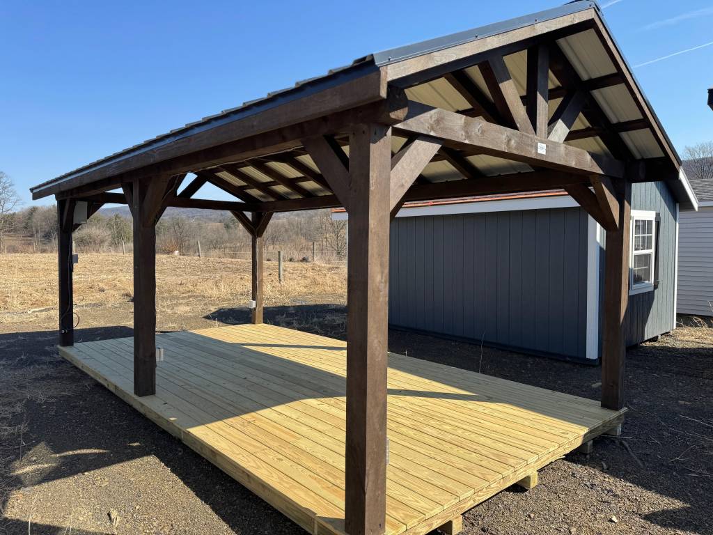 Stock Model 2022S, a 10x20 Sunrise Pavilion with a stained mushroom finish, matching mushroom trim, black metal roof, and a spacious open design. Side angle view