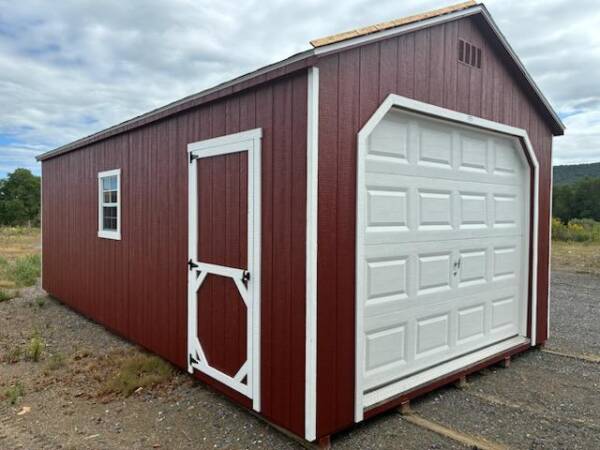 12x24 Smartside A‑Frame single garage (Model 2051S) in Shed Red with white trim and black architectural shingles; front-left view showing 9×7 garage door, man door, and a 24×27 window