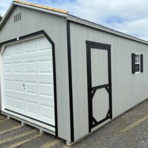 12x24 Smartside A‑Frame garage (Model 2052S) in Gap Gray with black trim and Charcoal Gray architectural shingles; front‑left view showing 9×7 garage door, man door, and 24×27 window with shutters